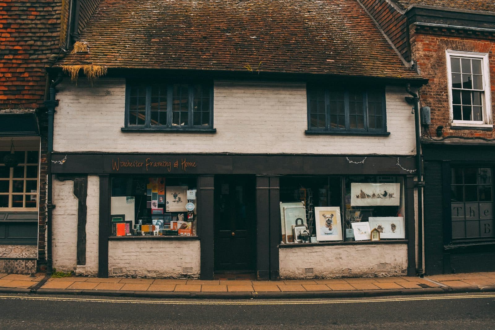 The storefront of a small neighbourhood shop in light brick.